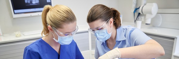 dentist and dental assistant do dental work on a patient
